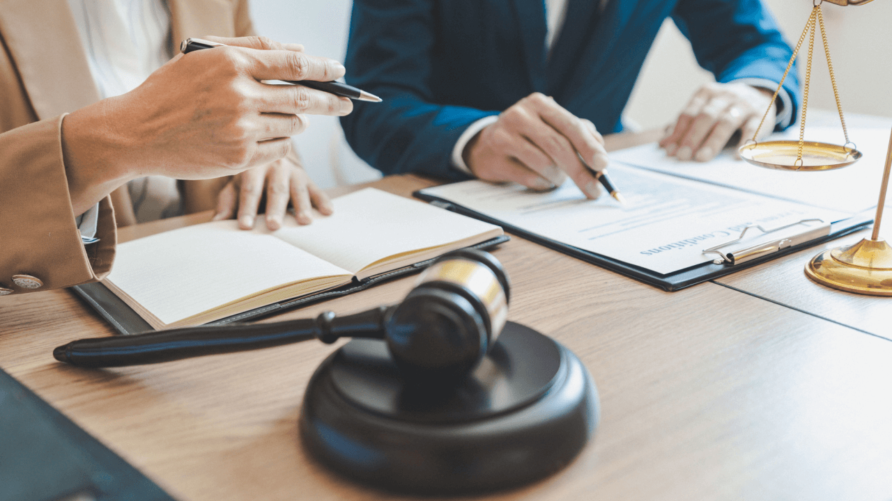 Client discussing how much does it cost for a debt lawyer during legal consultation with gavel and documents