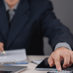 Professional calculating how much does a debt attorney cost using calculator and financial documents