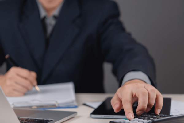 Professional calculating how much does a debt attorney cost using calculator and financial documents