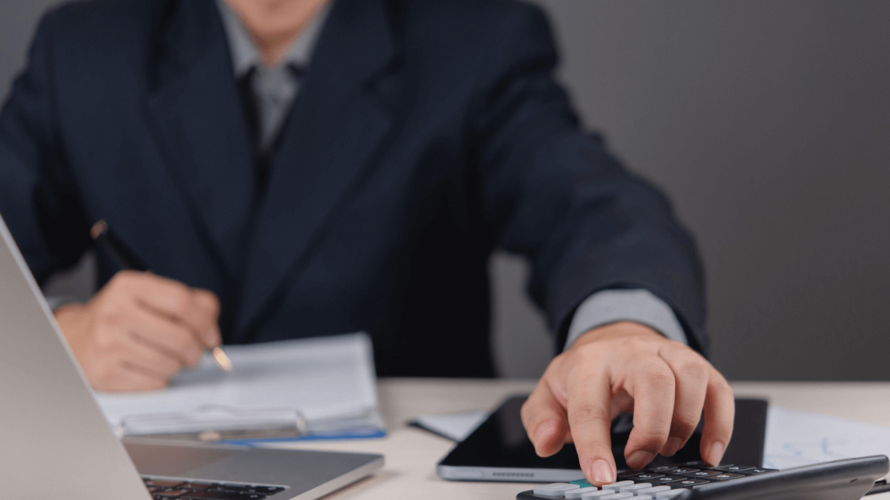 Professional calculating how much does a debt attorney cost using calculator and financial documents