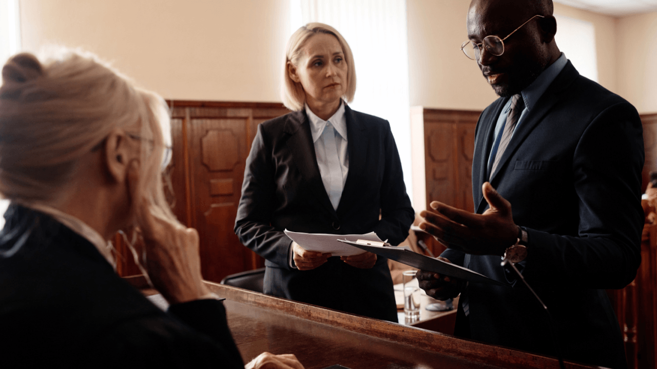 Criminal lawyer vs. criminal defense lawyer - legal team consulting with client in courtroom