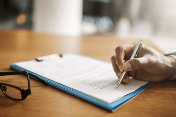 Person reviewing debt settlement documents with pen and clipboard asking is debt settlement ever a good idea