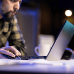 Is it better to settle a debt or go to court - Person researching whether it's better to settle a debt or go to court on laptop