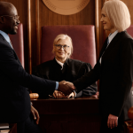 Two attorneys shaking hands in courtroom discussing is a defense attorney the same as a lawyer