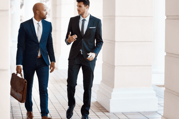 Two types of criminal lawyers discussing legal case in courthouse hallway