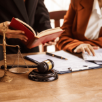 Criminal defense attorneys reviewing legal documents and case files with client during consultation