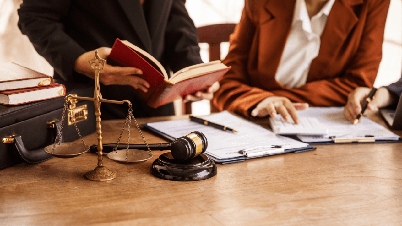 Criminal defense attorneys reviewing legal documents and case files with client during consultation