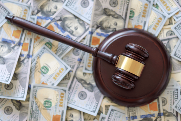 What is a reasonable amount to settle a debt - gavel on hundred dollar bills representing debt settlement negotiations