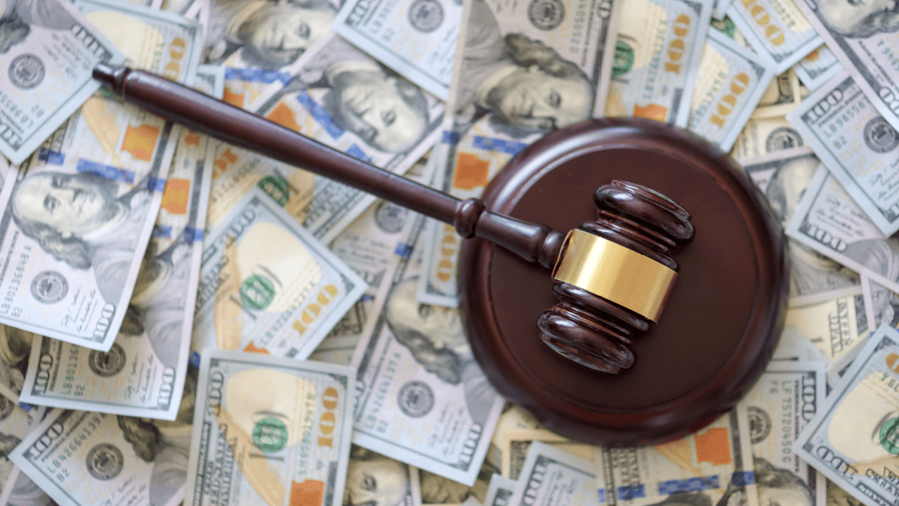 What is a reasonable amount to settle a debt - gavel on hundred dollar bills representing debt settlement negotiations