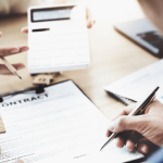 Person reviewing debt collector correspondence and contract documents to understand what is the worst thing a debt collector can do