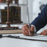 Legal professional signing documents with gavel and scales answering are prosecutors attorneys