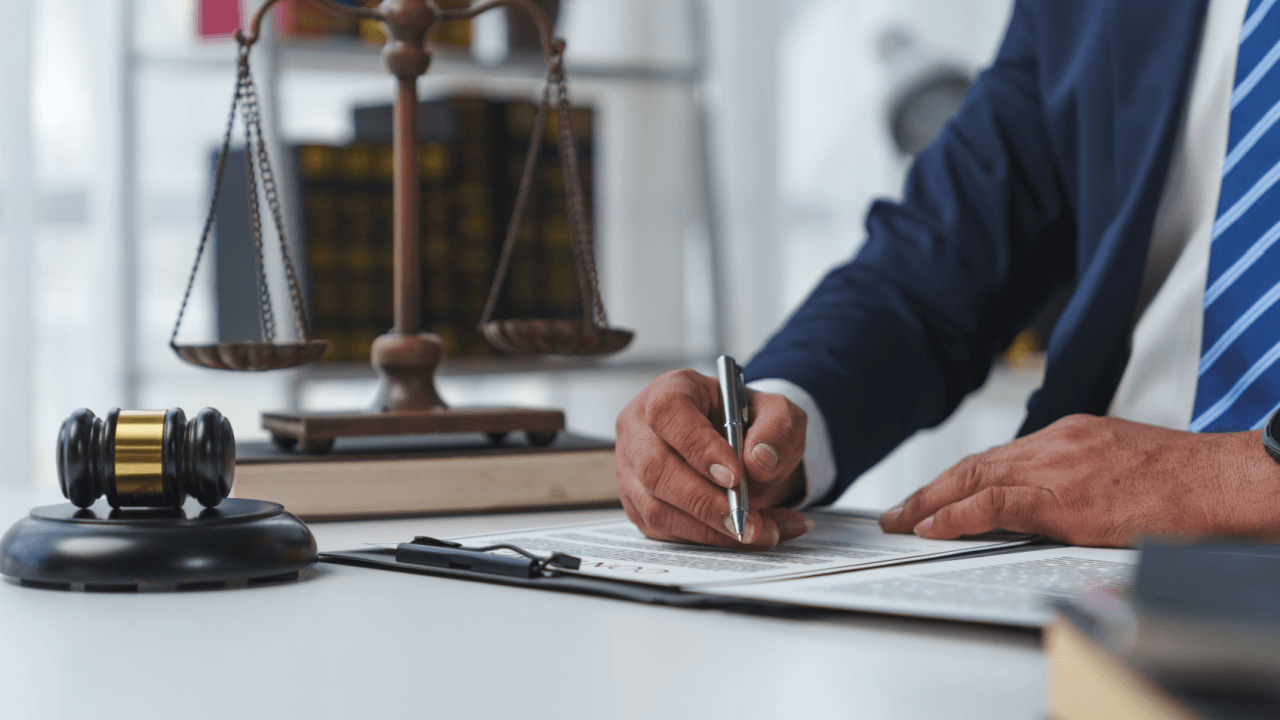 Legal professional signing documents with gavel and scales answering are prosecutors attorneys
