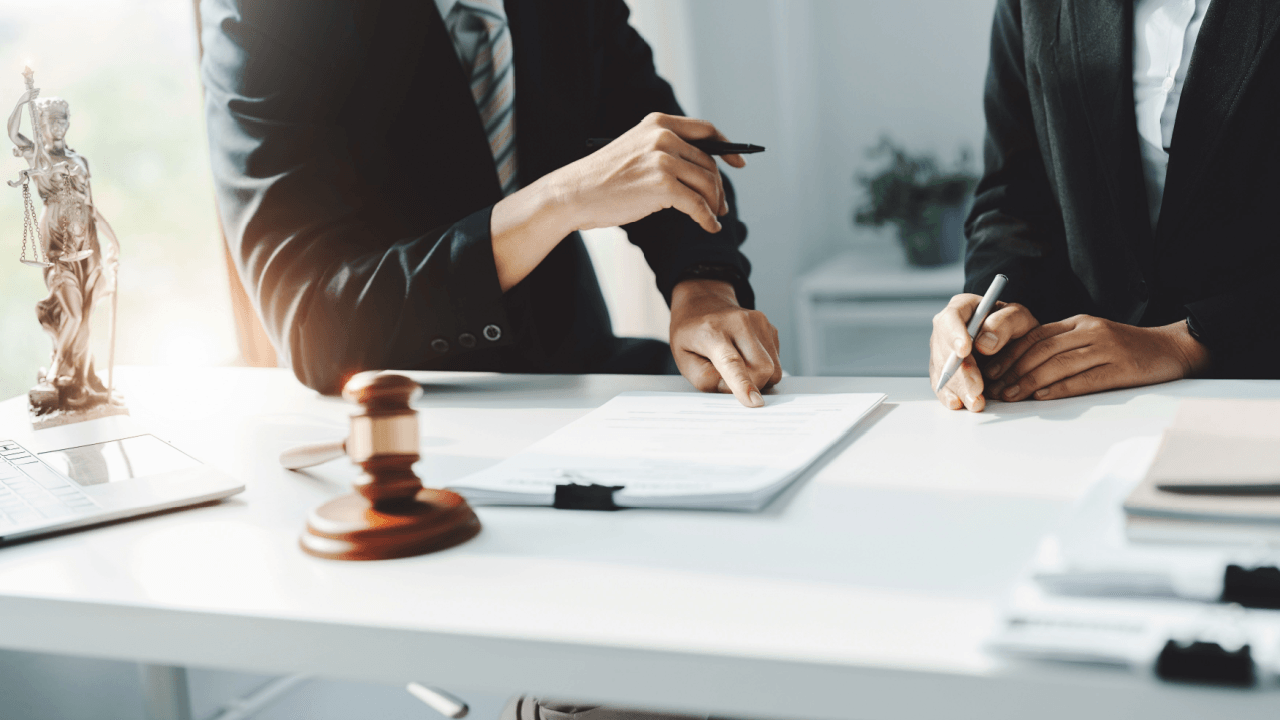 Legal professionals consulting over documents representing what do you call a lawyer that defends criminals
