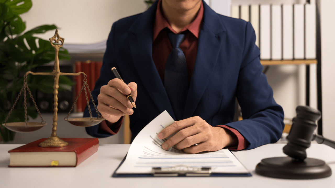 What does it take to be a criminal defense attorney reviewing legal documents at desk