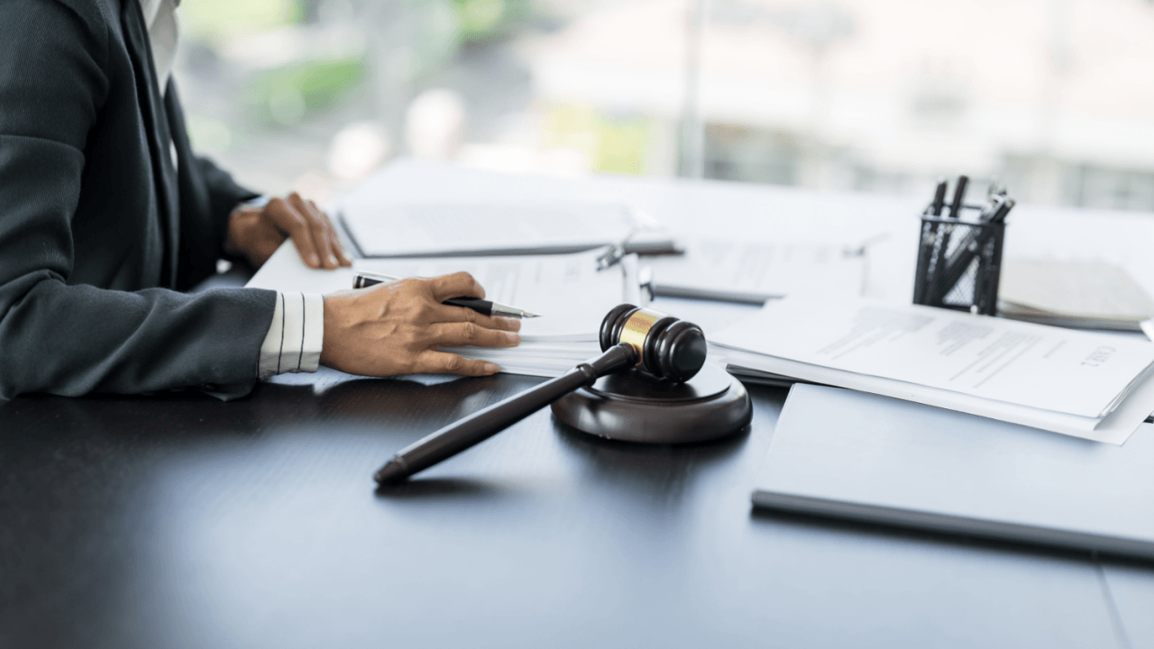 Legal professional reviewing documents with gavel representing what is a fancy word for advocate