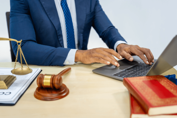 Why do criminal defense lawyers exist - attorney working on legal case at desk with gavel and scales of justice