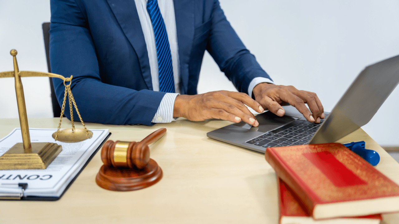 Why do criminal defense lawyers exist - attorney working on legal case at desk with gavel and scales of justice