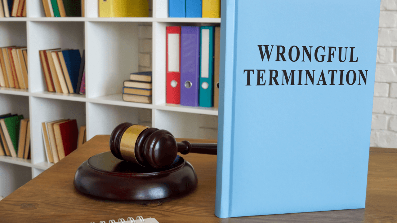 Wrongful termination law book beside a judge's gavel on a wooden desk