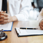 Wrongful termination lawsuit consultation with attorney reviewing legal documents and gavel on desk