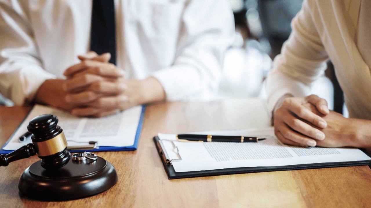 Wrongful termination lawsuit consultation with attorney reviewing legal documents and gavel on desk