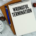 Wrongful termination notebook with gavel and clock on marble surface