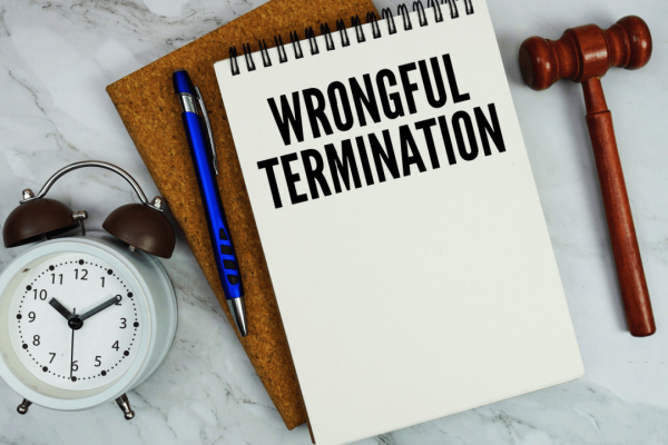 Wrongful termination notebook with gavel and clock on marble surface
