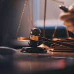 Wrongful termination lawyer at desk with judge's gavel and scales of justice in courtroom