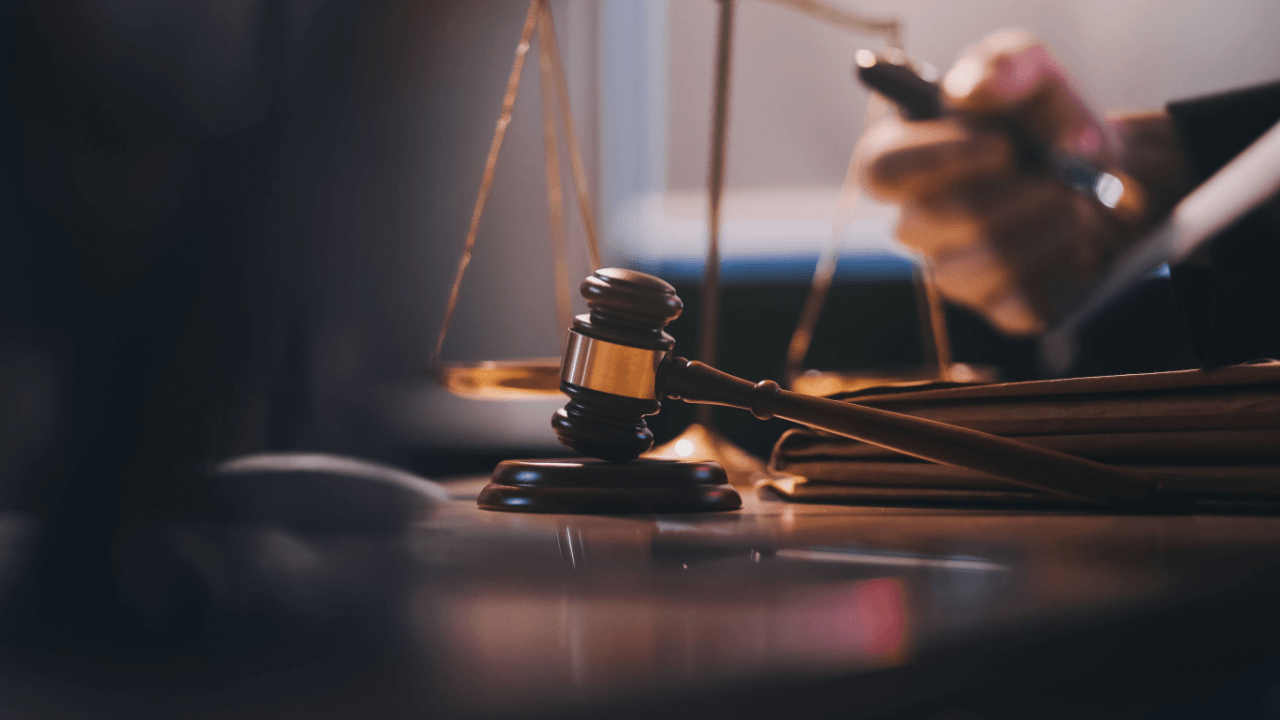 Wrongful termination lawyer at desk with judge's gavel and scales of justice in courtroom