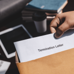 Person holding a termination letter in an envelope