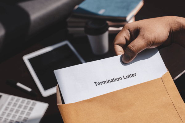 Person holding a termination letter in an envelope