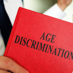 Legal professional holding Age Discrimination book representing age discrimination employee rights