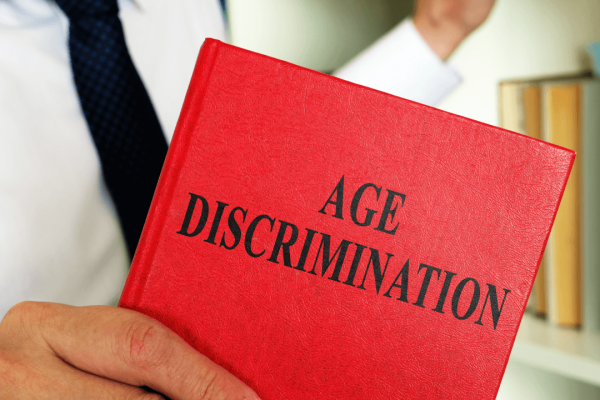 Legal professional holding Age Discrimination book representing age discrimination employee rights