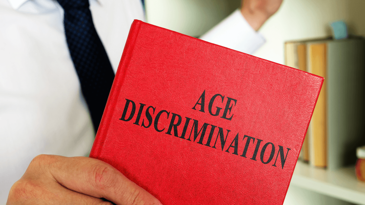 Legal professional holding Age Discrimination book representing age discrimination employee rights