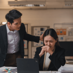 Distressed employee facing workplace intimidation depicting retaliation after reporting harassment