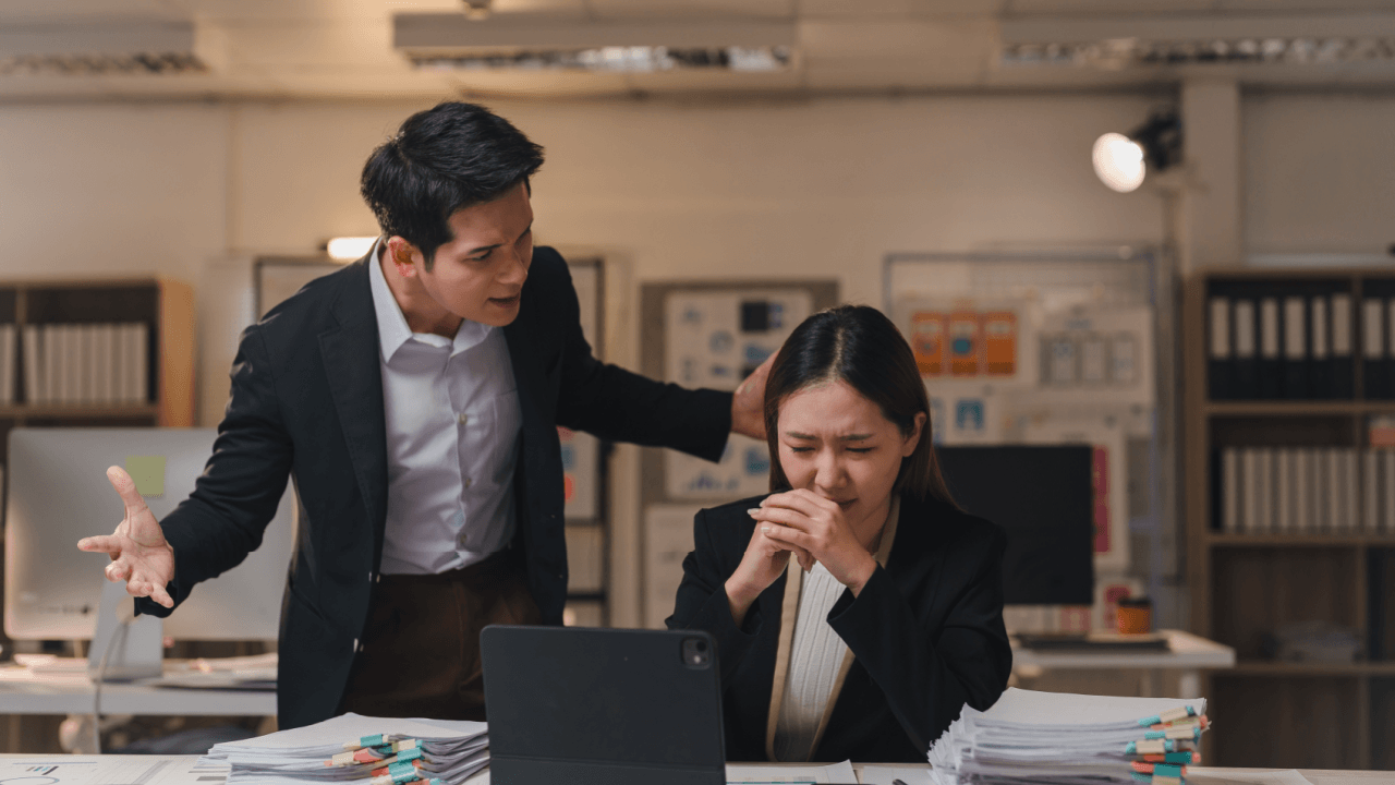 Distressed employee facing workplace intimidation depicting retaliation after reporting harassment