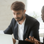 Two professionals reviewing a wrongful termination case document at a desk