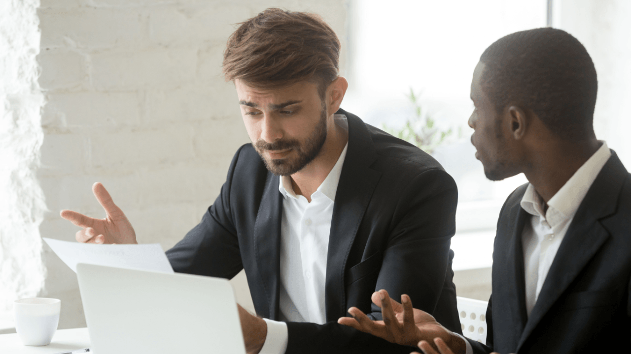 Two professionals reviewing a wrongful termination case document at a desk