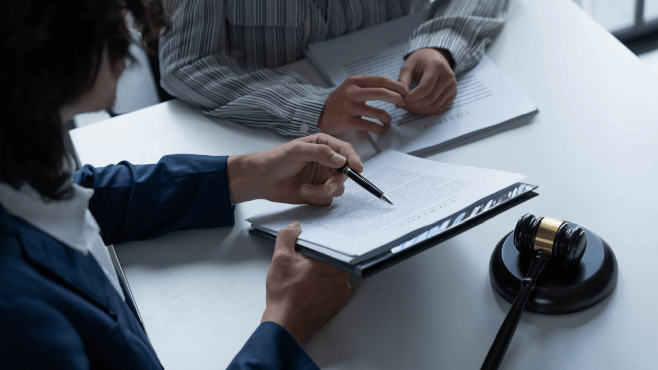 Attorney reviewing legal documents with client in disability discrimination by employers case