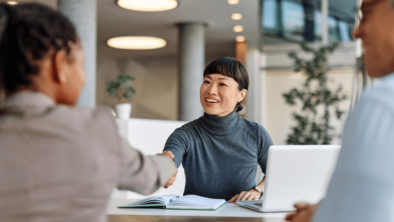 Attorney greeting client with handshake to discuss religious discrimination laws at work