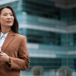 Workplace discrimination lawyer reviewing case details on tablet outside corporate office building