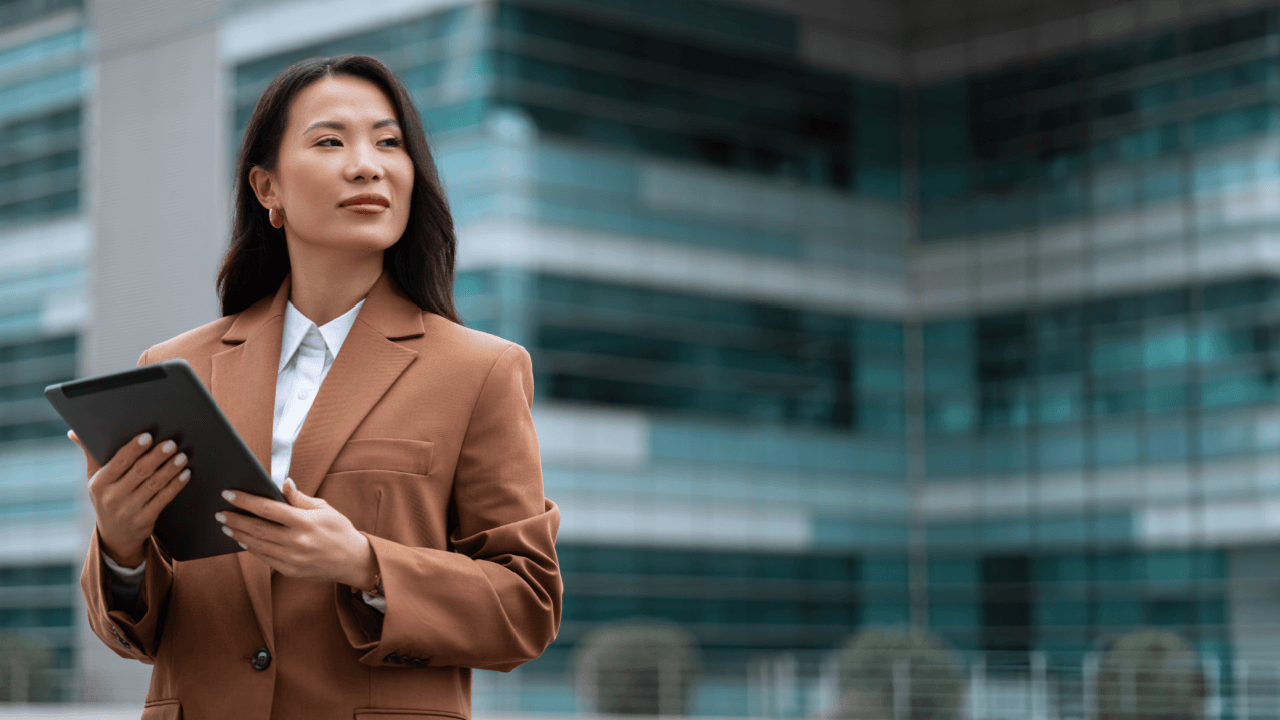 Workplace discrimination lawyer reviewing case details on tablet outside corporate office building