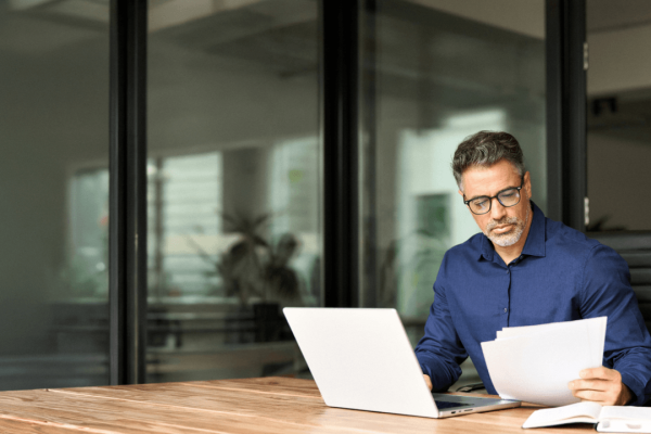 Workplace retaliation lawyer reviewing legal documents at office desk with laptop