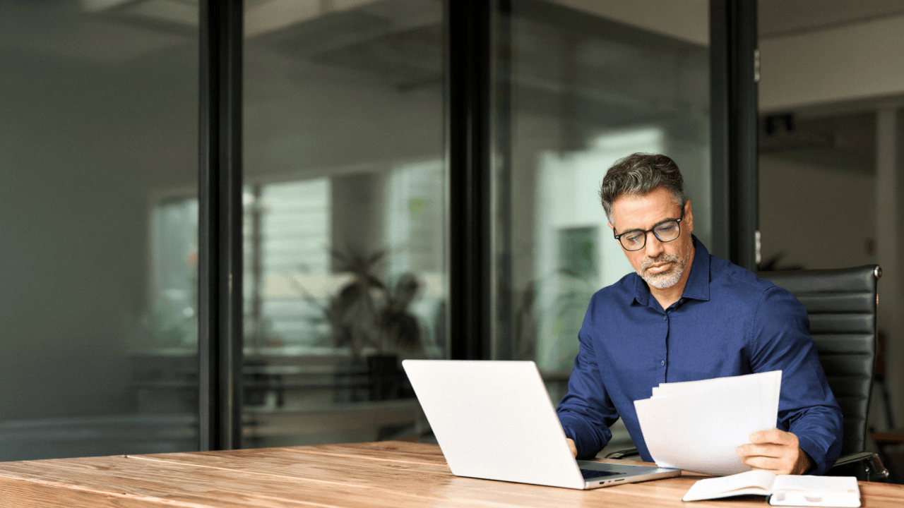 Workplace retaliation lawyer reviewing legal documents at office desk with laptop