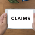 Person holding tablet displaying claims screen representing the wrongful termination claims process