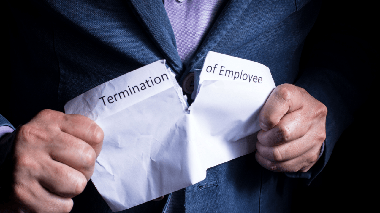 Man tearing termination of employment document