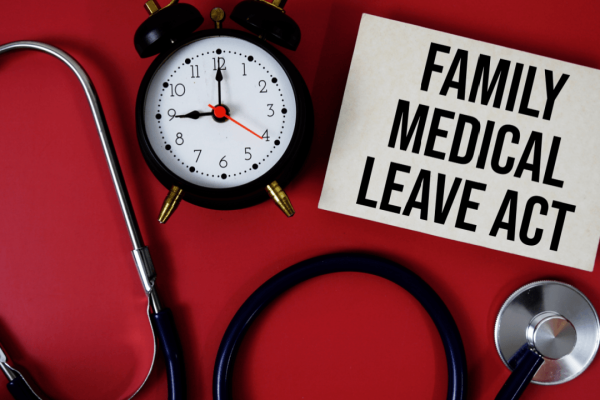 Family Medical Leave Act sign with clock and stethoscope showing can you be fired while on FMLA leave