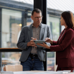 Employee and manager reviewing tablet discussing returning to work after FMLA leave in office