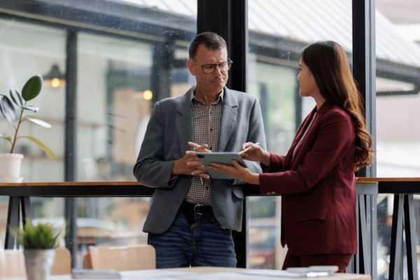 Employee and manager reviewing tablet discussing returning to work after FMLA leave in office