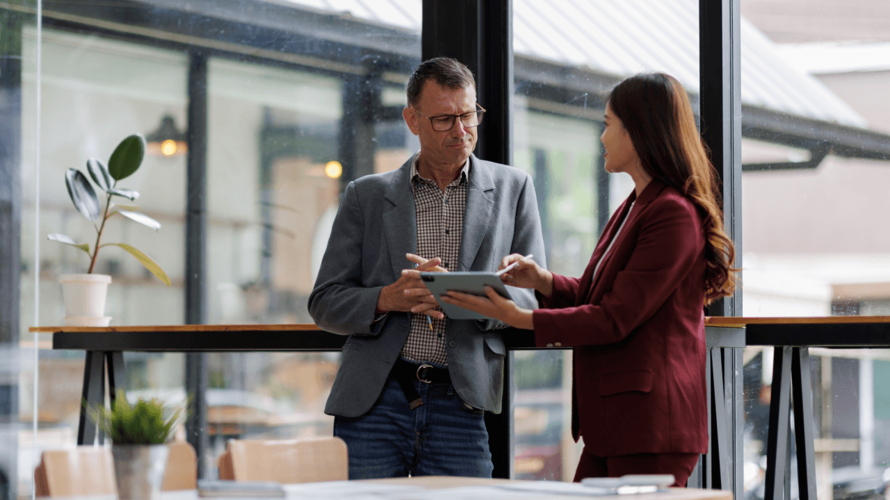 Employee and manager reviewing tablet discussing returning to work after FMLA leave in office
