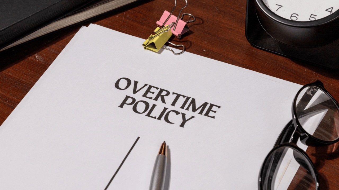 Overtime policy document on desk representing unpaid overtime employee rights in the workplace